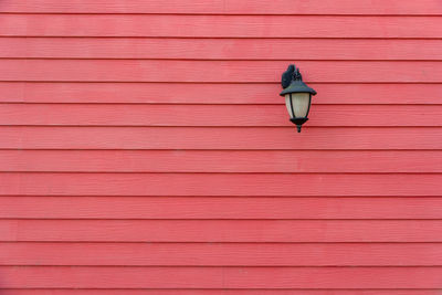 Pink umbrella on wooden wall