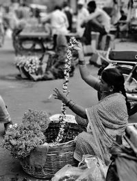 Side view of female vendor selling flowers at market