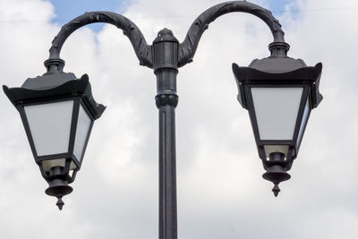 Low angle view of street light against cloudy sky