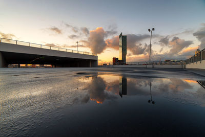 Floodlight reflection in puddle against sky