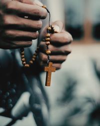 Close-up of human hand holding cross