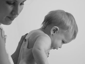 Close-up of mother giving bath to baby boy