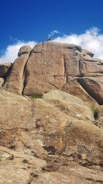 Low angle view of rock formation on land against sky