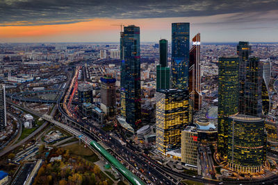 High angle view of illuminated buildings in city at sunset