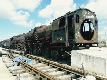 Steam train on railroad track against sky