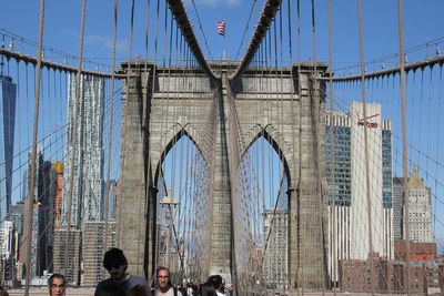 Panoramic view of suspension bridge in city against sky