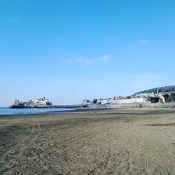 Scenic view of beach against blue sky