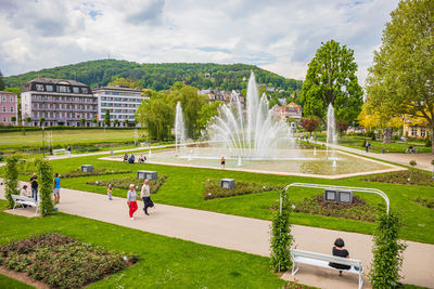 People in park by city against sky