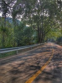 Road by trees against sky