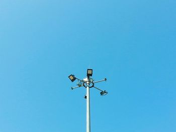 Low angle view of crane against clear blue sky