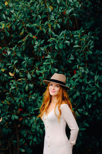 Portrait of woman standing by plants