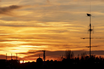 Low angle view of silhouette tower against dramatic sky during sunset