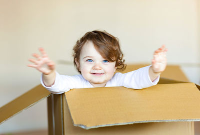 Portrait of cute girl with blue eyes in cardboard box
