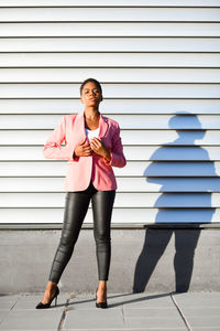 Portrait of confident businesswoman standing on sidewalk in city