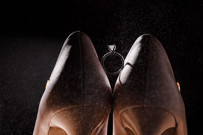 Low section of shoes against black background