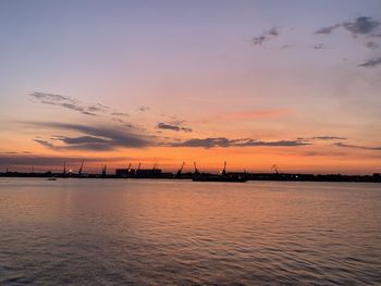 Silhouette pier over sea against sky during sunset