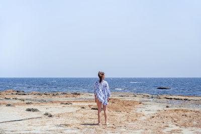 Mid adult woman standing at beach during vacation