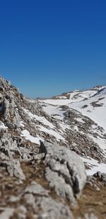 Scenic view of snowcapped mountains against clear blue sky