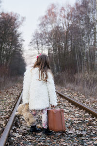 Rear view of girl on railroad track