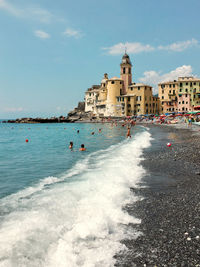 View of buildings by sea against sky