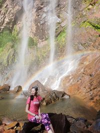 Woman standing by waterfall