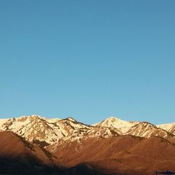 Scenic view of mountains against clear blue sky