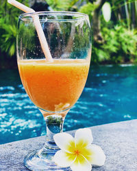 Close-up of drink on table by swimming pool