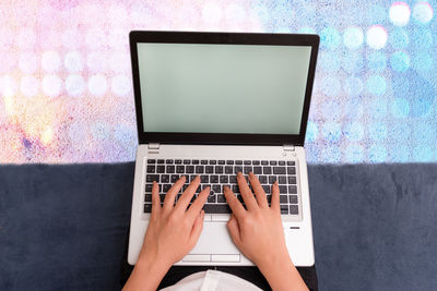 Low section of person using mobile phone on table