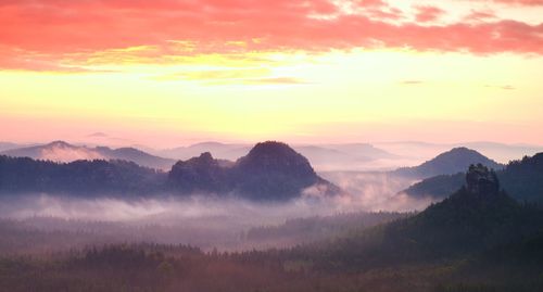 Scenic view of mountains against orange sky