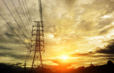 Low angle view of silhouette electricity pylon against sky during sunset