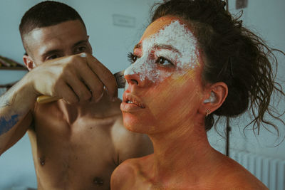 Man applying mask to woman