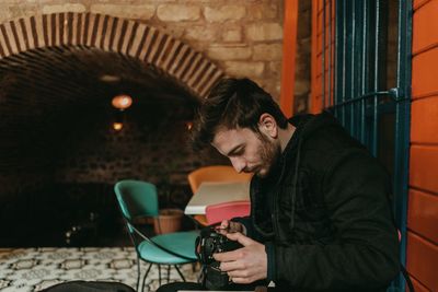 Man looking at camera while sitting indoors. 