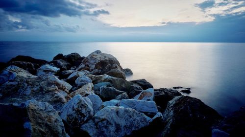 Rocks by sea against sky