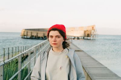 Portrait of woman on pier over sea against sky