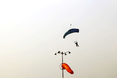 Low angle view of person paragliding against clear sky