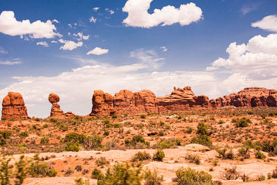 Rock formations on landscape against cloudy sky