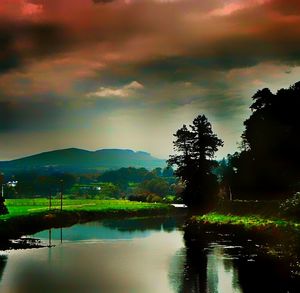 Scenic view of lake by silhouette trees against sky