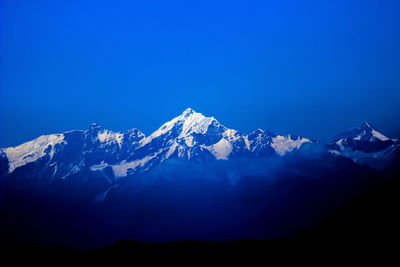 Scenic view of snowcapped mountains against clear blue sky