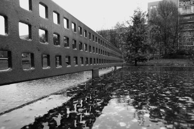 Reflection of building in puddle on street