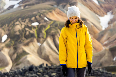 Young woman hiker walking around iceland's highlands and mossy hills