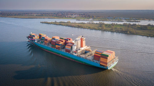 High angle view of container ship in sea against sky