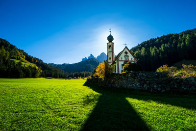 Built structure by trees against blue sky