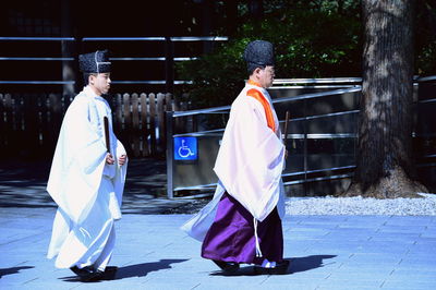 Side view of man and woman standing on footpath