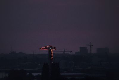 Communications tower in city against clear sky