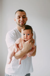 Midsection of father holding daughter while sitting at home