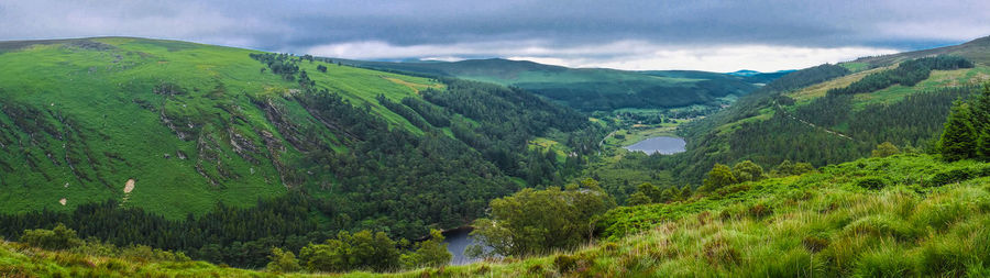 View of lush green landscape against cloudy sky