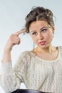 Portrait of young woman against white background