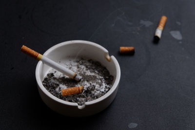 High angle view of cigarettes in ashtray on table