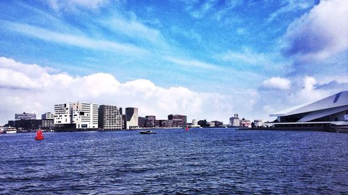 Buildings in city against cloudy sky