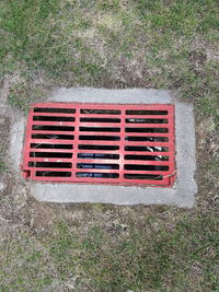 High angle view of red metal grate on grass
